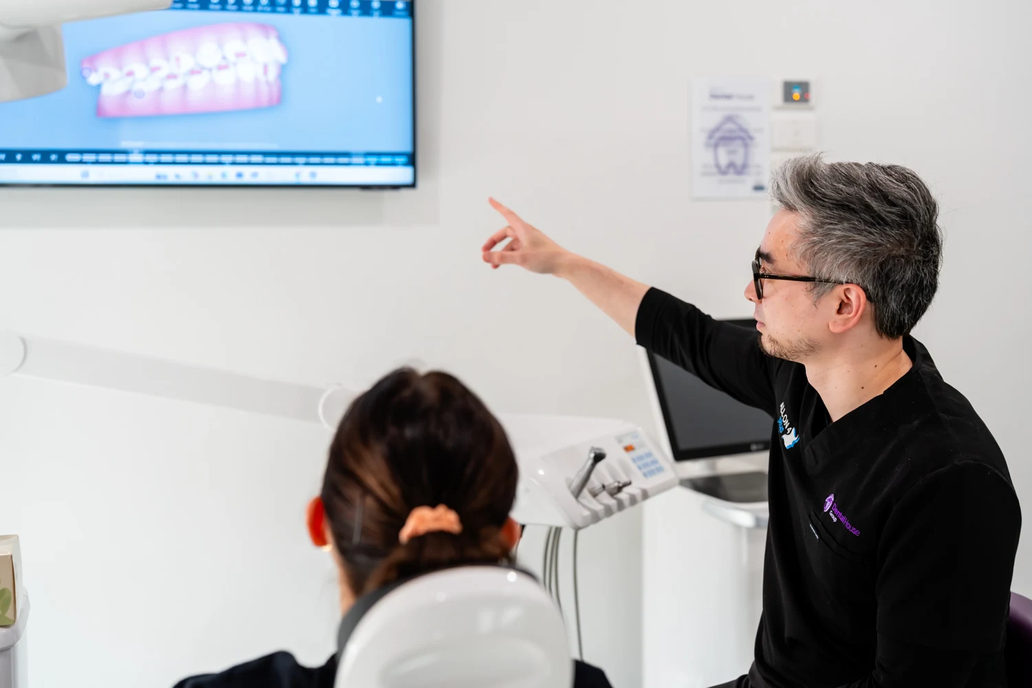 Dentist and patient looking monitor showing dental bridge