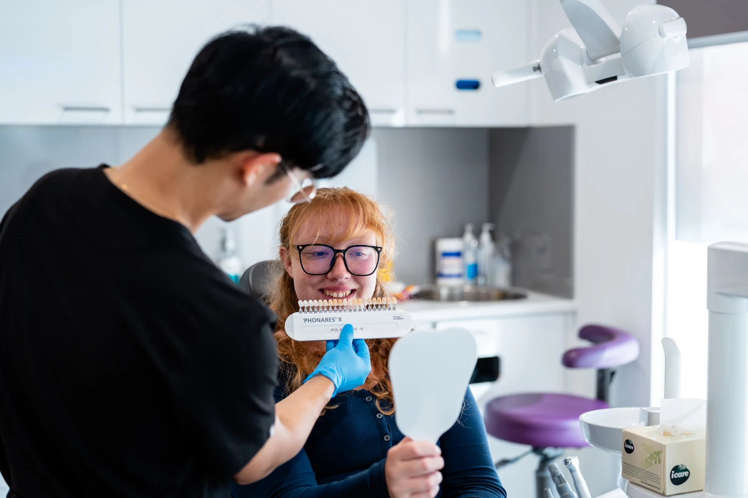 Dentist and patient try to match veneers teeth